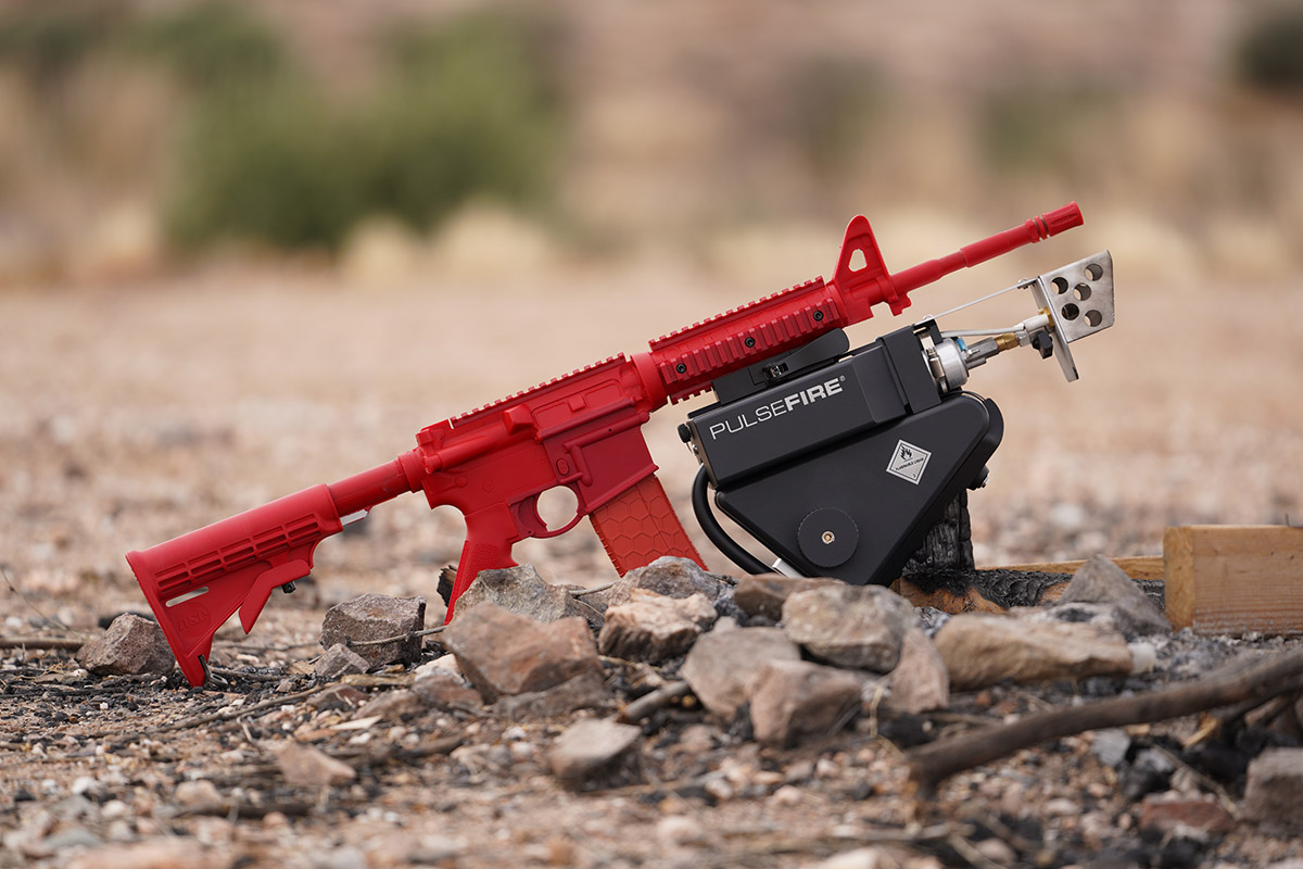 Red plastic AR15 with Pulsefire UBF attached, rocky desert environment.