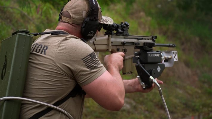 Man holding Pulsefire UBF equipped SCAR-H with backpack kit.