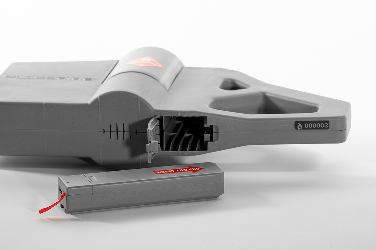 Detail of battery pack next to Pulsefire Compact with open battery access panel.